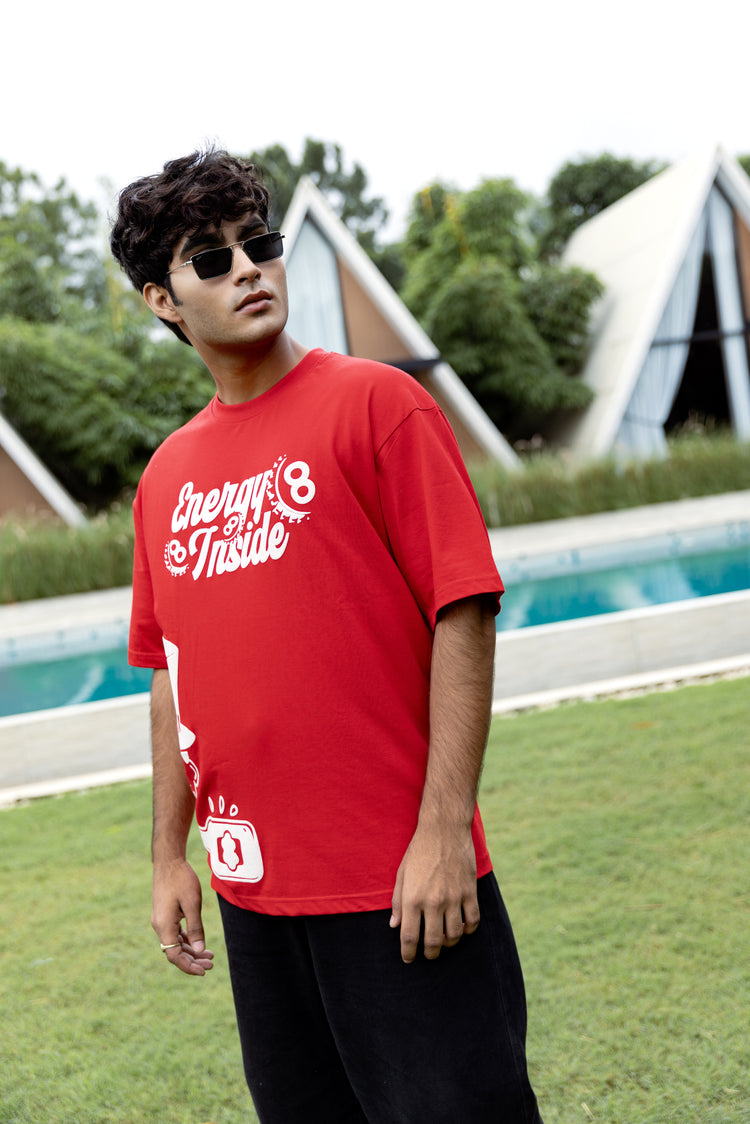 Person wearing a red t-shirt with text outdoors by a pool