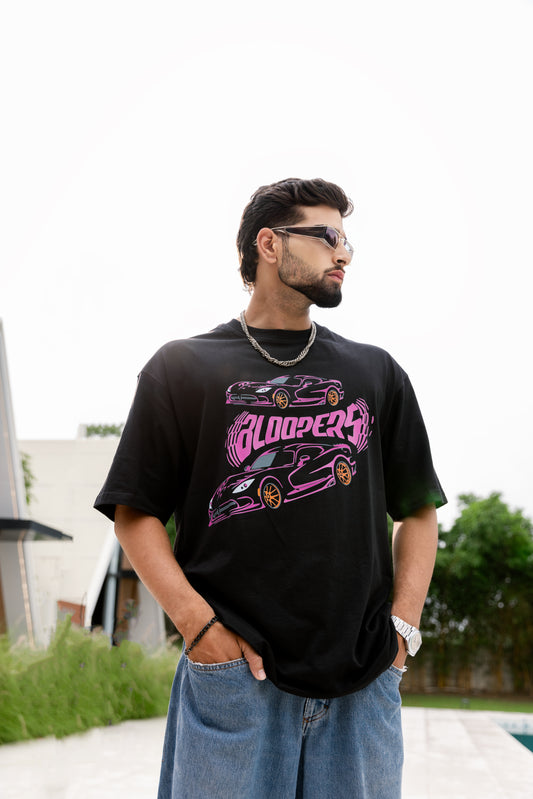 Man wearing a black t-shirt with car graphics and 'Bloppers' text, standing outdoors.