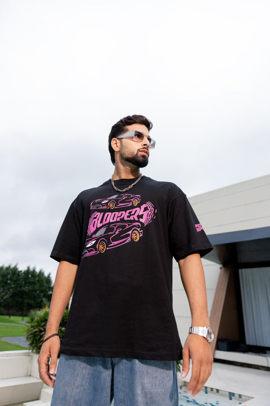 Man wearing a black t-shirt with pink graphics outdoors