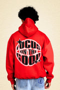 Person wearing a red hoodie with 'Focus on the Good' text 