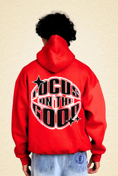Person wearing a red hoodie with 'Focus on the Good' text 