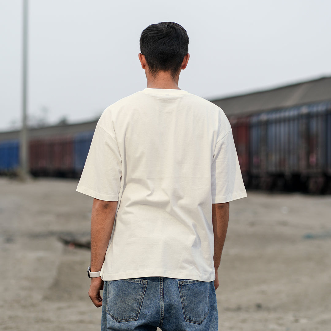 Person wearing a beige shirt and jeans.