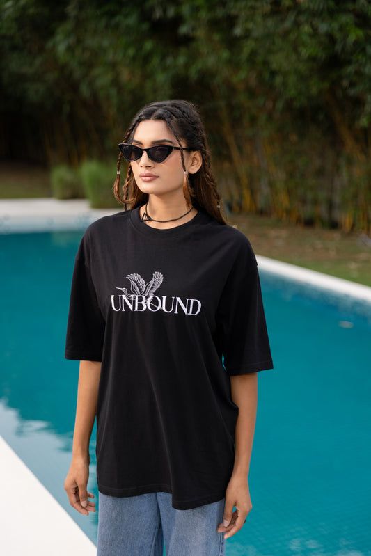 Woman wearing a black 'UNBOUND' t-shirt by a pool