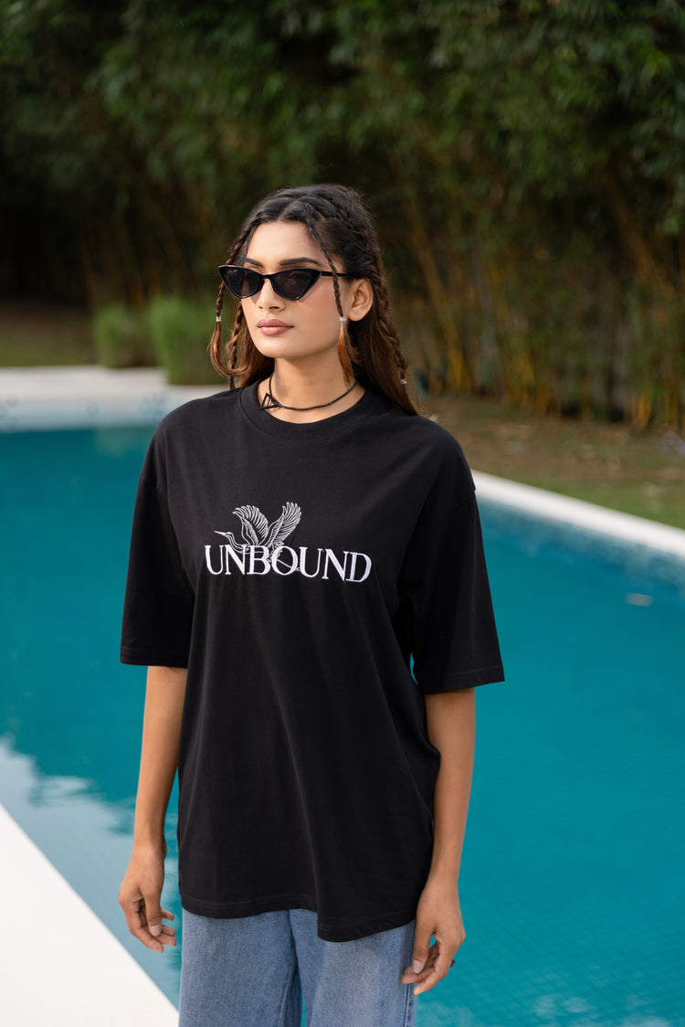 Woman wearing a black 'UNBOUND' t-shirt by a pool