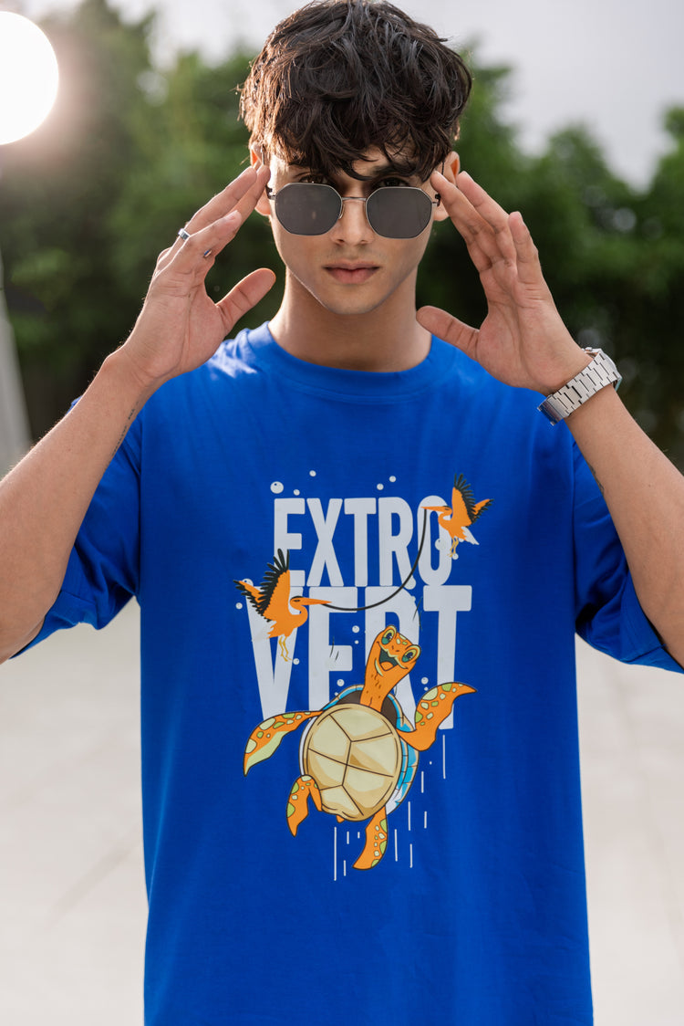 Person wearing a blue t-shirt with a turtle graphic and 'EXTROVERT' text.