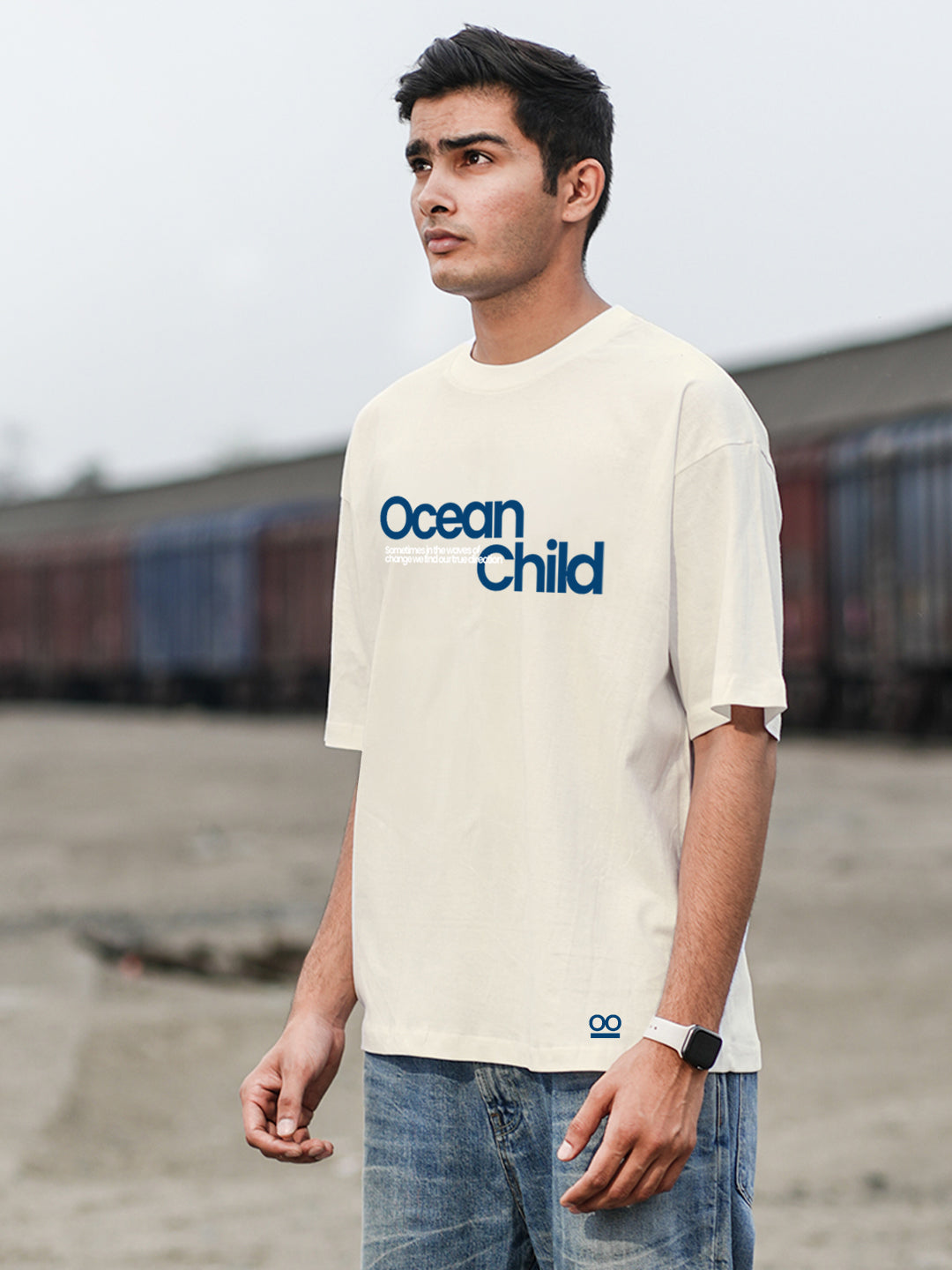 Person wearing a beige t-shirt with 'Ocean Child' text.