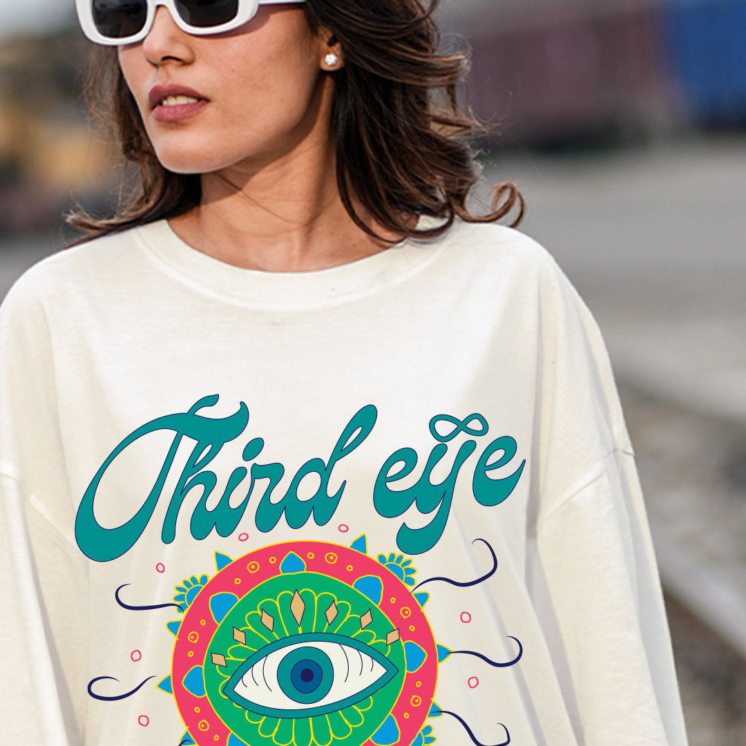 Person wearing a white sweatshirt with 'Third eye' design outdoors
