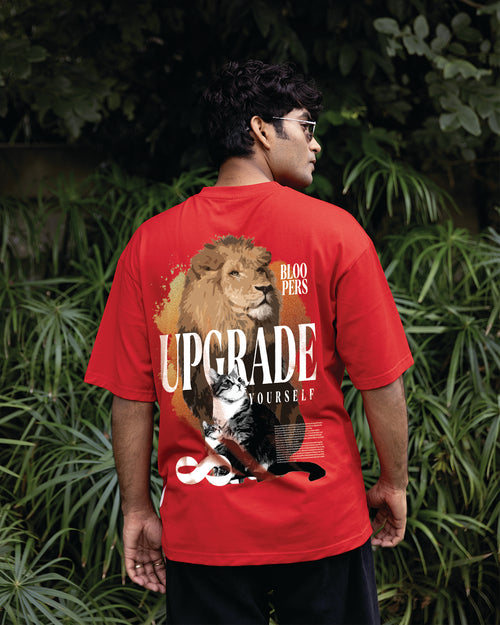 Person wearing a red oversize t-shirt with a lion and cat graphic 