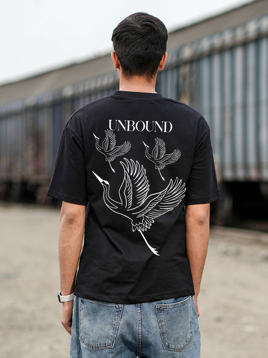 Person wearing a black t-shirt with 'UNBOUND' design outdoors